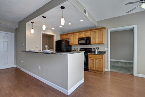 A kitchen with wooden cabinets and a granite countertop.