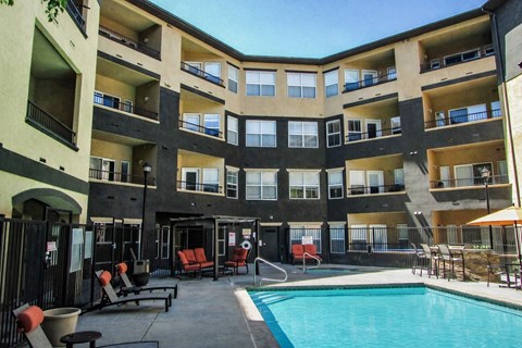 A large apartment complex with a pool and patio area.