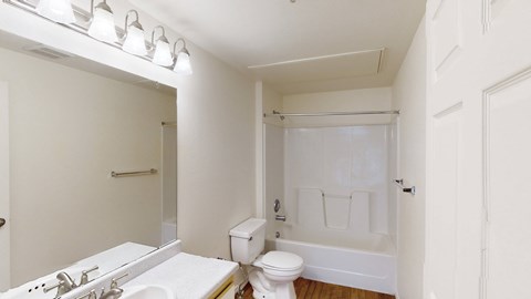 A white bathroom with a toilet, sink, and bathtub.