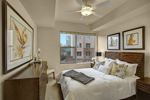 A bedroom with a large bed and a ceiling fan.