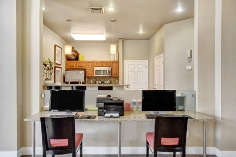 A kitchen with a table and chairs in front of it.