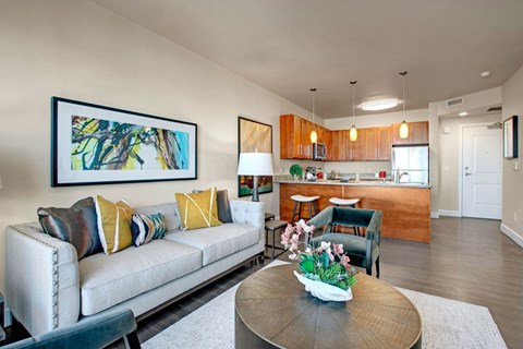 A living room with a couch, coffee table, and a painting on the wall.