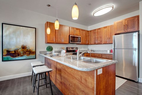 A kitchen with wooden cabinets and a painting on the wall.