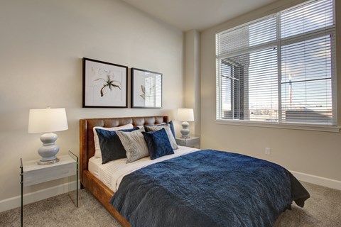A bedroom with a large bed and two lamps.