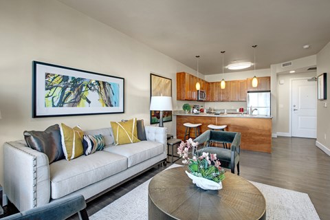 A living room with a couch, coffee table, and a painting on the wall.