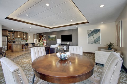 A dining room with a wooden table and white chairs.