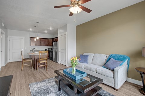 A living room with a couch, chairs, and a dining table.