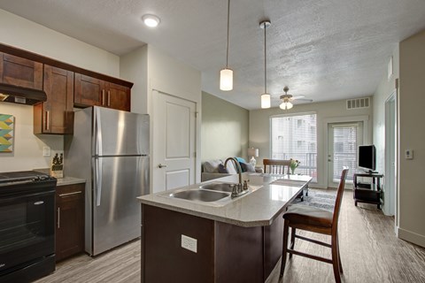 A kitchen with a refrigerator, sink, and cabinets.