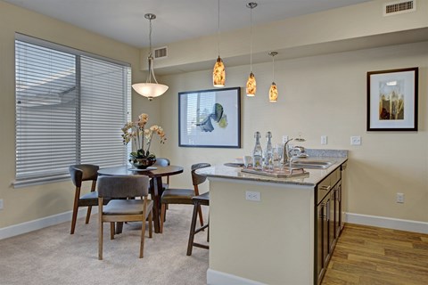 A kitchen with a table and chairs and a painting hanging on the wall.