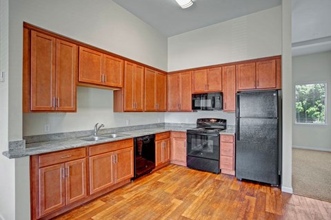 A kitchen with wooden cabinets and black appliances.