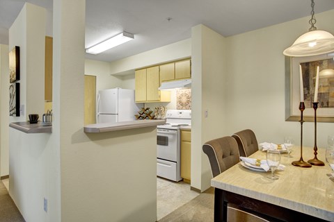 A modern kitchen with a dining table set for two.