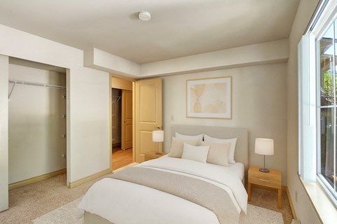 A bedroom with a large bed and a painting on the wall.