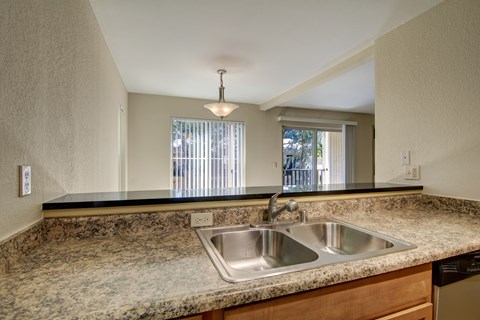 A kitchen with granite countertops and a double sink.