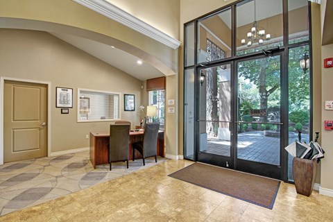 A foyer with a table and chairs and a glass door.