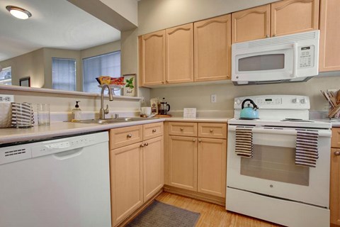 A kitchen with wooden cabinets and white appliances.
