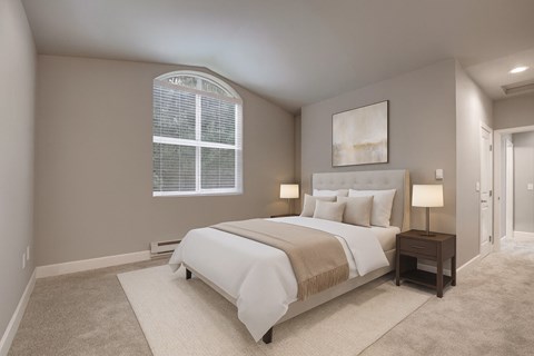A bedroom with a large bed and a window with blinds.