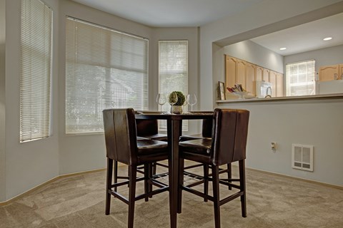 A dining room with a table and chairs.