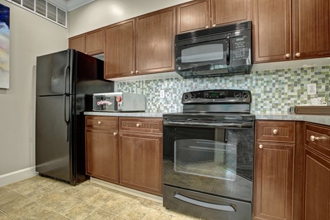 A kitchen with brown cabinets and black appliances.