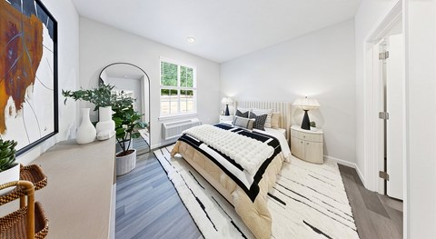 A bedroom with a large bed and a painting on the wall.