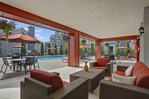 A patio with red couches and a table with a vase on it.