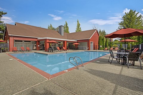 A red building with a pool in front.