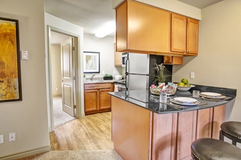 A kitchen with wooden cabinets and a black countertop.