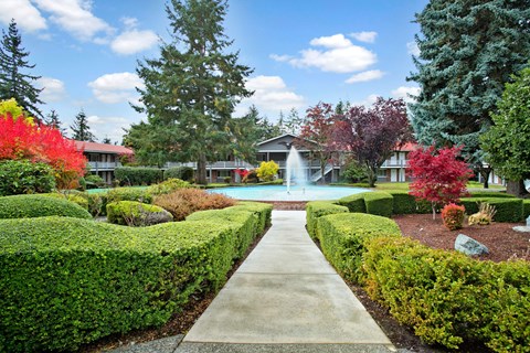 A garden with a fountain in the middle of it.