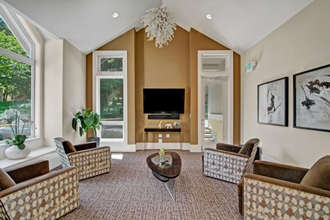 A living room with a brown carpet and a television.