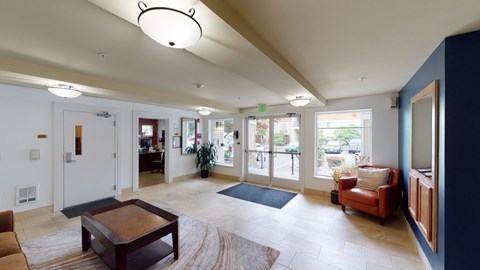 A living room with a brown coffee table and a red chair.