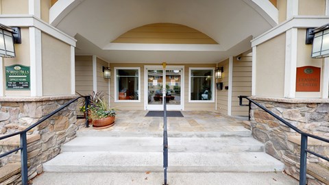 The entrance to a building with a stone wall and a planter on the steps.