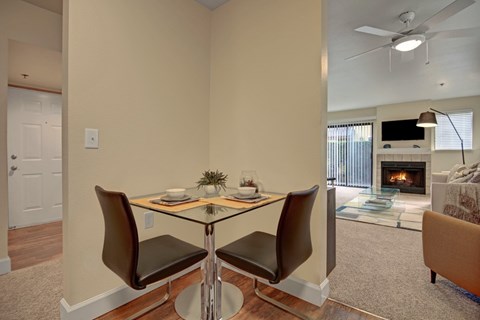 A dining room with a glass table and chairs.