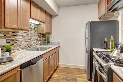 A kitchen with wooden cabinets and a black refrigerator.