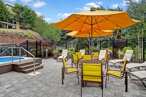A patio with a table and chairs and an umbrella.