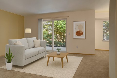 A living room with a white couch, a wooden coffee table, and a plant.