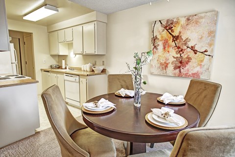 A dining room with a table set for two.