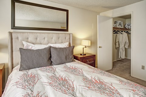 A bedroom with a large bed and a mirror above it.
