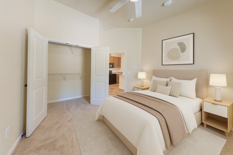 A bedroom with a large bed and a ceiling fan.