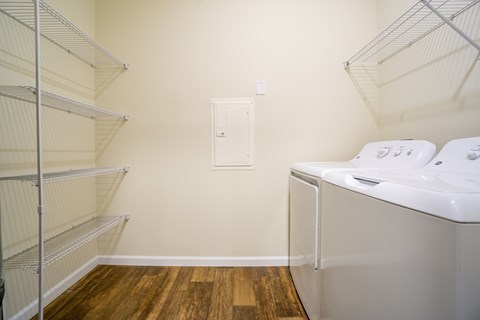 A laundry room with a washer and dryer and a white door.