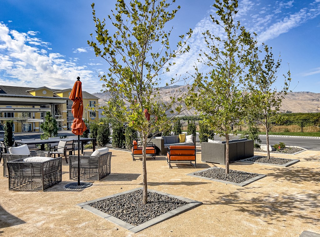an outdoor patio with trees and a building in the background