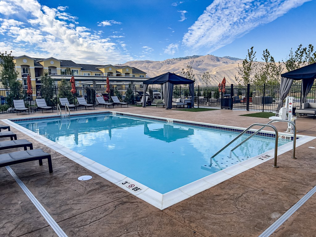 a resort style pool with lounge chairs and gazebos