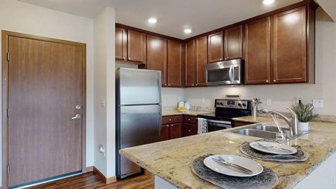A kitchen with brown cabinets and a granite countertop.