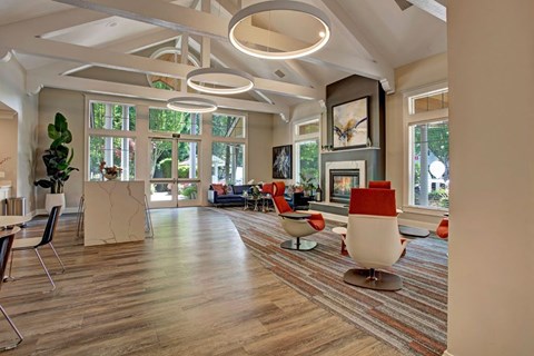 A living room with a white couch and red chairs.