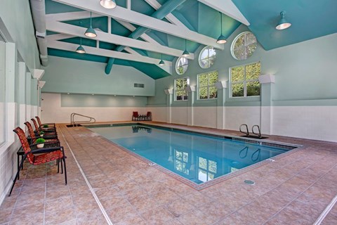 A large indoor swimming pool with a glass bottom.