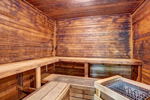 A wooden sauna with a bench and a hot tub.