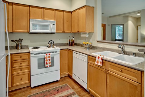 A kitchen with wooden cabinets and white appliances.