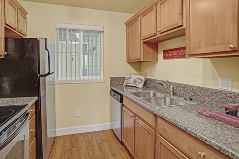 A kitchen with wooden cabinets and granite countertops.