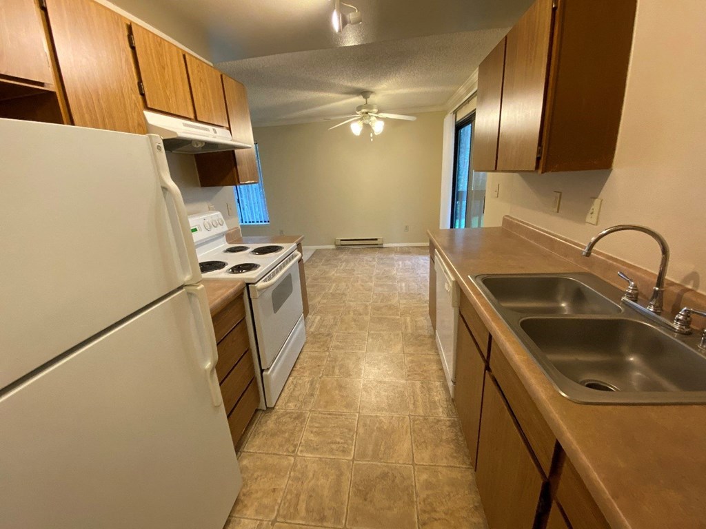 an empty kitchen with a sink and a refrigerator
