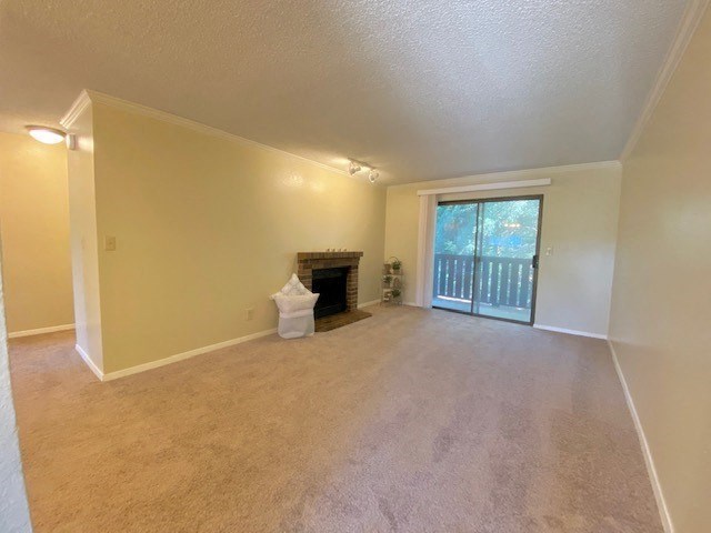 an empty living room with a fireplace and a sliding glass door