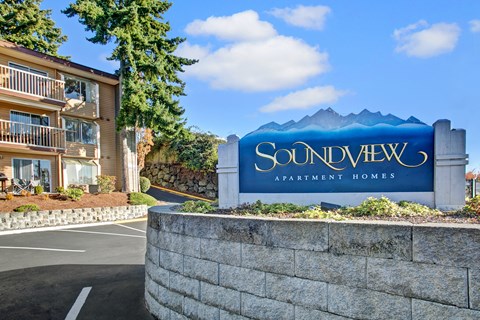 A sign for Soundview Apartment Homes in front of a building.