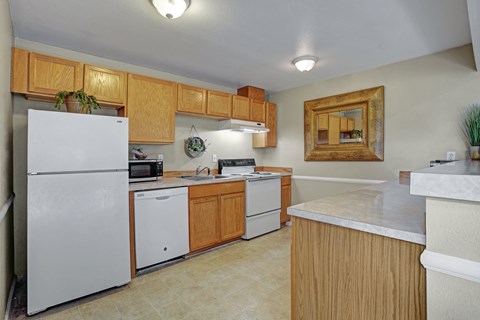 A kitchen with a white refrigerator and wooden cabinets.
